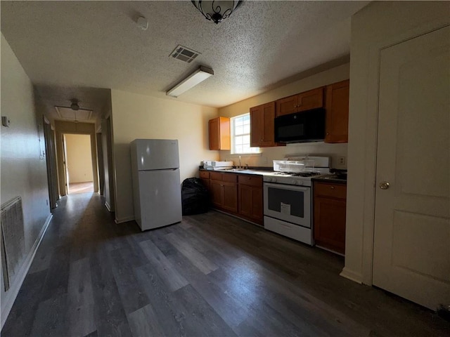 kitchen featuring visible vents, white appliances, brown cabinets, and dark wood-style floors