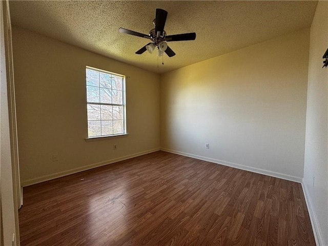 unfurnished room featuring dark wood finished floors, a ceiling fan, baseboards, and a textured ceiling