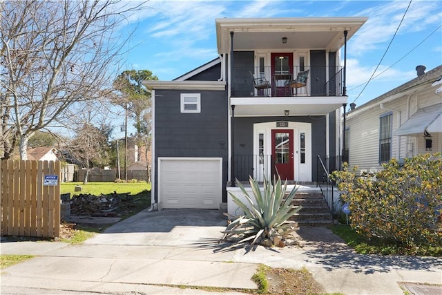 view of front of home with a garage, a balcony, concrete driveway, and fence