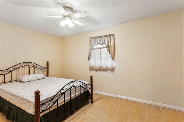 bedroom with ceiling fan, baseboards, and a textured ceiling