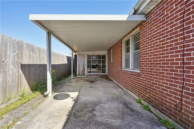 view of patio with an attached carport and fence