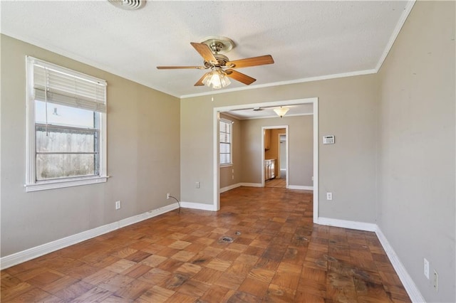 unfurnished room featuring baseboards, a textured ceiling, ceiling fan, and crown molding