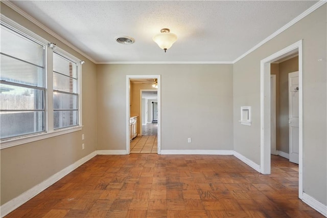 empty room featuring a ceiling fan, baseboards, visible vents, a textured ceiling, and crown molding