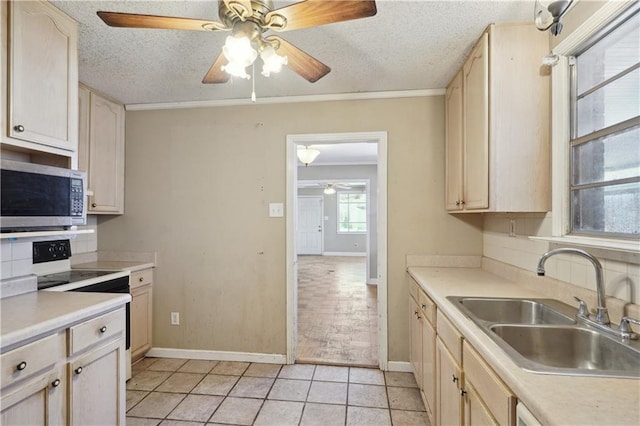 kitchen featuring stainless steel microwave, ceiling fan, light tile patterned floors, electric range, and a sink