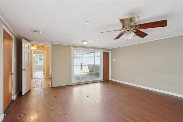 unfurnished room featuring visible vents, ornamental molding, a textured ceiling, and wood finished floors