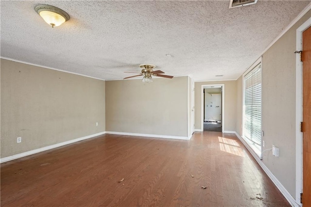 spare room featuring visible vents, wood finished floors, crown molding, baseboards, and ceiling fan