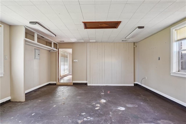 empty room with baseboards and concrete flooring