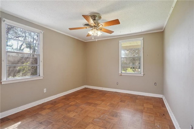 spare room with ceiling fan, crown molding, baseboards, and a textured ceiling