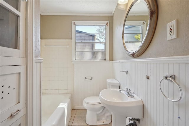 bathroom with a wainscoted wall, toilet, ornamental molding, and tile patterned flooring