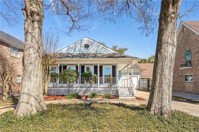 view of front facade with an attached garage, covered porch, and driveway