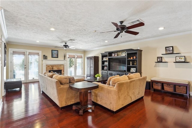 living room with visible vents, a fireplace, dark wood-style flooring, french doors, and crown molding