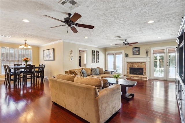 living room featuring dark wood-type flooring, visible vents, and a wealth of natural light