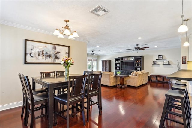 dining area with visible vents, crown molding, baseboards, ceiling fan with notable chandelier, and dark wood-style floors