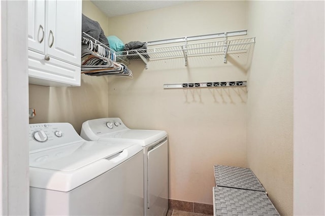 clothes washing area featuring washing machine and clothes dryer and cabinet space