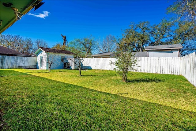 view of yard featuring an outdoor structure, a fenced backyard, and a shed