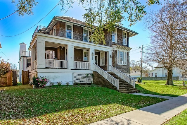 view of front facade with a porch, stairway, fence, and a front yard