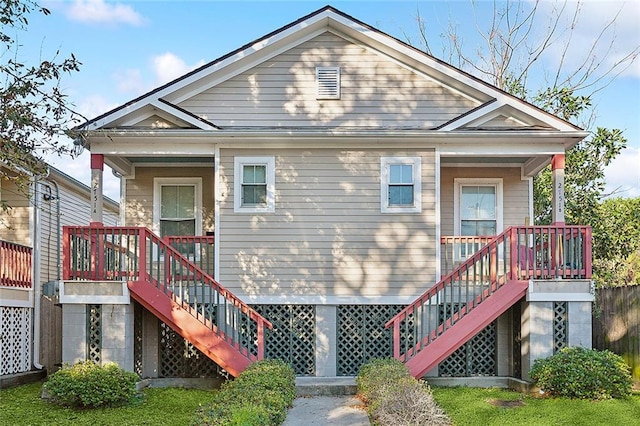 rear view of property featuring stairway and covered porch