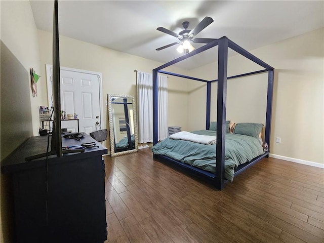 bedroom with dark wood finished floors, a ceiling fan, and baseboards