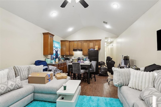 living room with dark wood finished floors, vaulted ceiling, visible vents, and ceiling fan