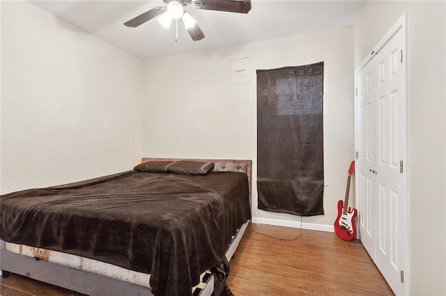 bedroom with a ceiling fan, baseboards, and wood finished floors