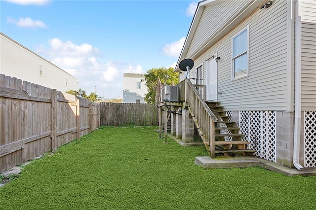 view of yard featuring stairway, central AC, and a fenced backyard