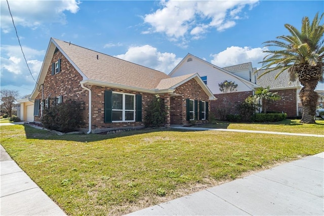 traditional-style home featuring a front yard, brick siding, and roof with shingles