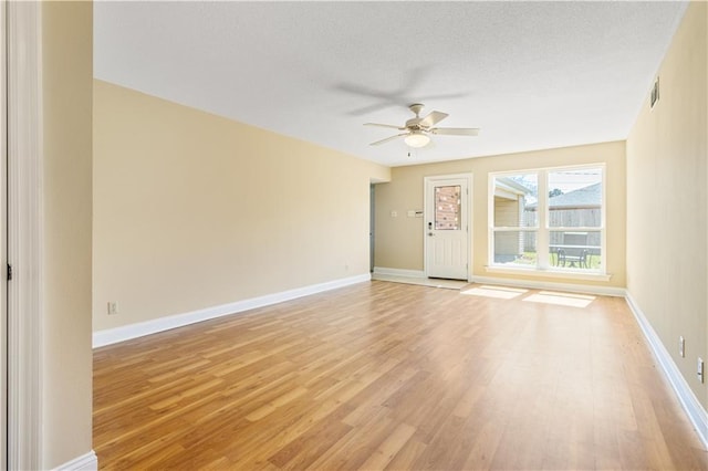 unfurnished room featuring light wood-type flooring, baseboards, visible vents, and a ceiling fan