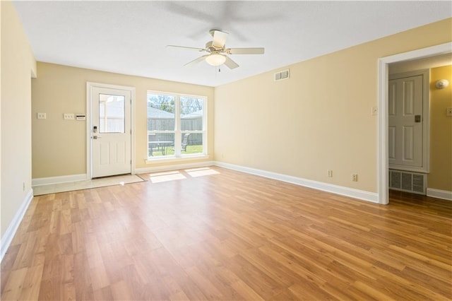 empty room featuring visible vents, light wood-style flooring, a ceiling fan, and baseboards