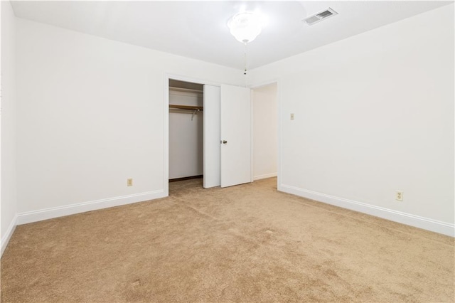 unfurnished bedroom with visible vents, baseboards, light colored carpet, and a closet