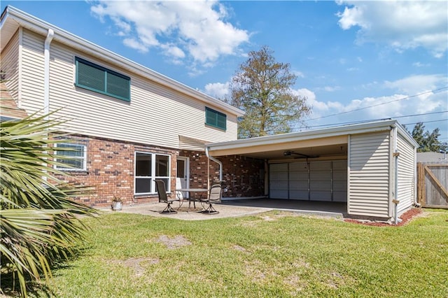 rear view of house featuring brick siding, fence, a yard, a patio area, and driveway