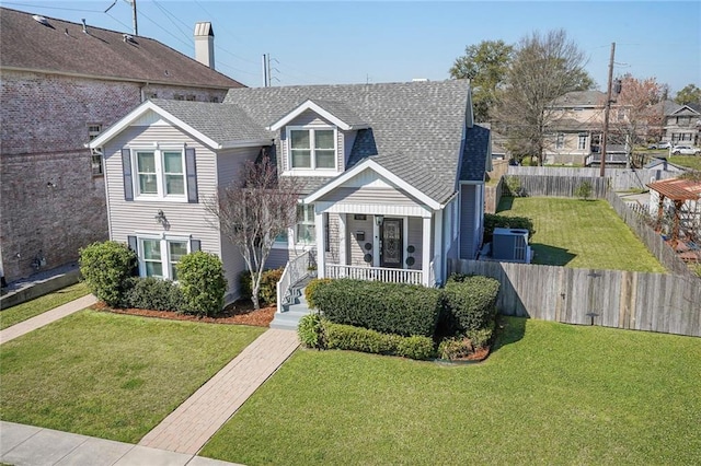 view of front of property featuring roof with shingles, a porch, a front yard, and fence