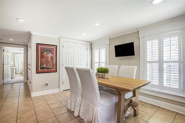 dining area featuring crown molding, light tile patterned floors, baseboards, and a wealth of natural light