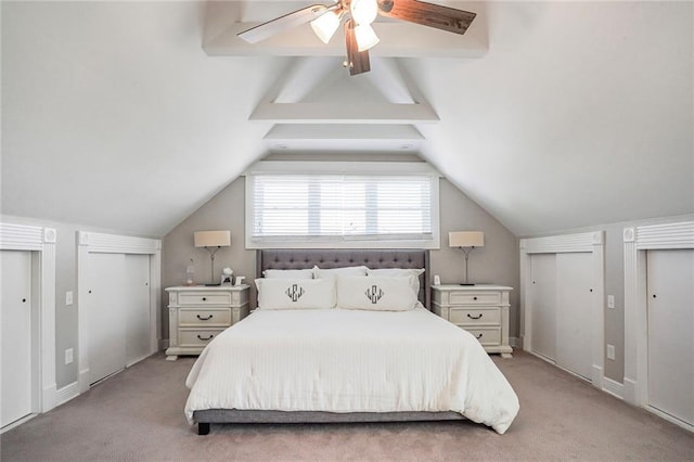 bedroom featuring lofted ceiling, a ceiling fan, two closets, and light carpet