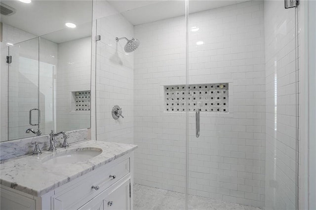 full bathroom featuring vanity, a shower stall, recessed lighting, and visible vents