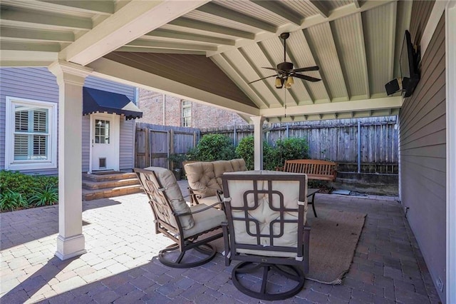 view of patio featuring outdoor dining area, a ceiling fan, and fence