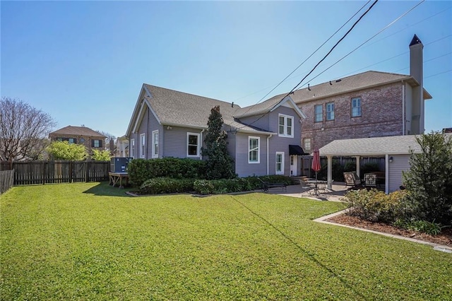 back of house with a lawn, a patio, and fence