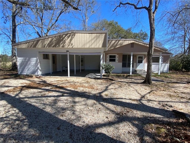 view of front of house with an attached carport and dirt driveway