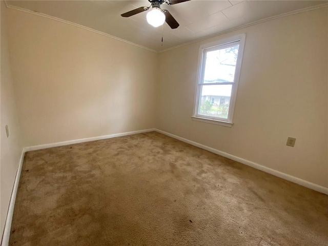 spare room featuring carpet flooring, a ceiling fan, crown molding, and baseboards