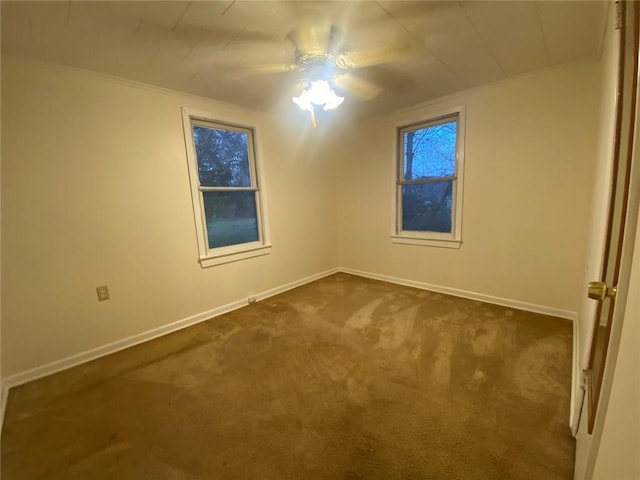 empty room with crown molding, baseboards, and dark colored carpet