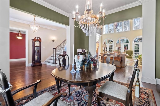 dining area with an inviting chandelier, stairway, wood finished floors, and ornamental molding