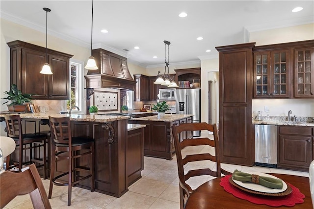 kitchen with custom exhaust hood, a peninsula, stainless steel appliances, dark brown cabinetry, and a kitchen bar