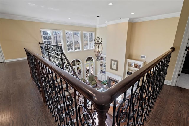 hallway featuring wood finished floors, an upstairs landing, and ornamental molding