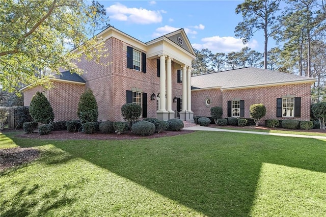 neoclassical home featuring brick siding and a front lawn