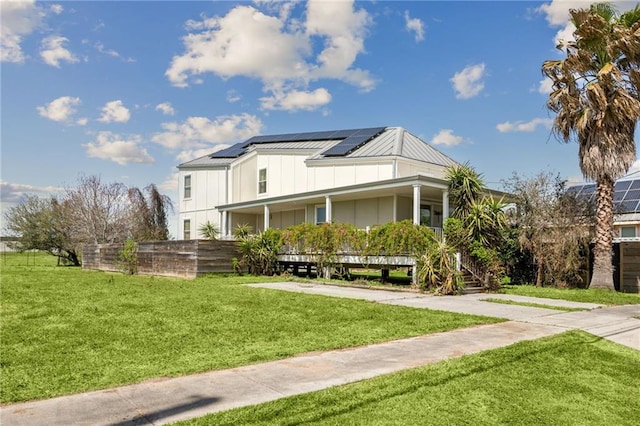 view of side of property with a lawn, board and batten siding, and solar panels