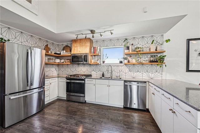 kitchen with open shelves, decorative backsplash, white cabinets, stainless steel appliances, and a sink