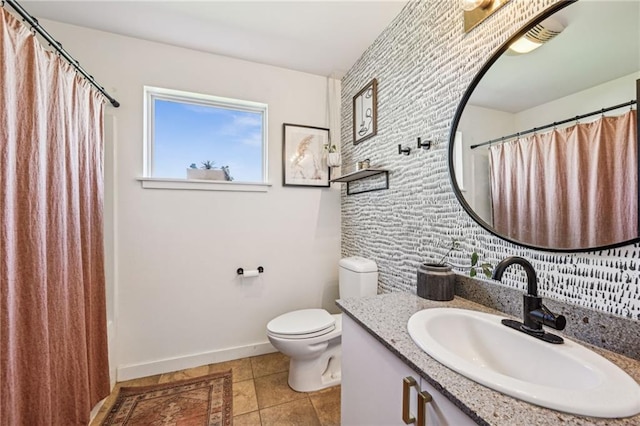 bathroom with vanity, toilet, baseboards, and tile patterned flooring