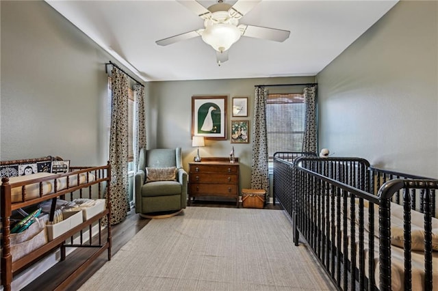 bedroom featuring a crib and ceiling fan