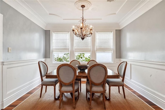 dining room featuring plenty of natural light, dark wood-type flooring, and a wainscoted wall