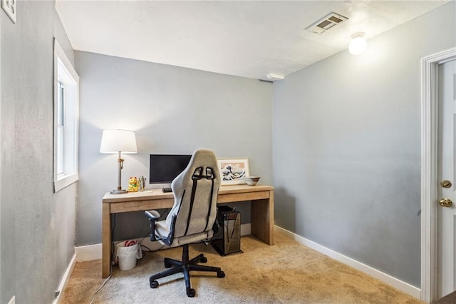 carpeted office space featuring visible vents and baseboards