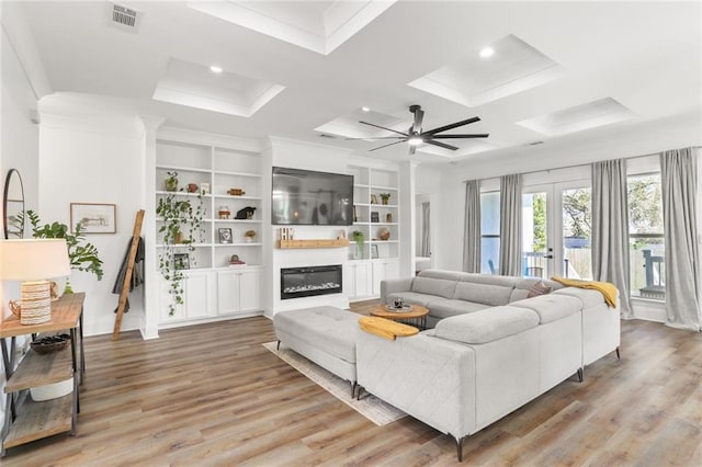 living area with light wood finished floors, visible vents, french doors, and a glass covered fireplace